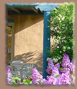 Lilacs and wild rose bushes bloom around the patio at the Guadalupe Inn in Santa Fe, New Mexico. Guests of the Inn enjoy "Santa Fe