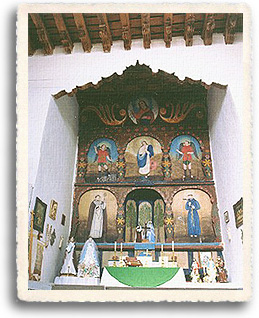 The altar at the church of San Jose de Gracia at Las Trampas showing the whitewashed walls. The altar itself is surrounded by retablos and santos made by local santeros.