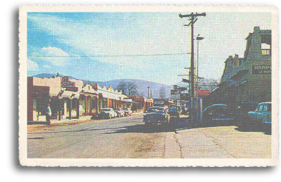 A view of Kit Carson Road in downtown Taos, New Mexico (circa 1940s). Named after the famed mountain man, Kit Carson, the road is a main byway lined with galleries, shops and other businesses, leading to the location of the historic Kit Carson Home and Museum.