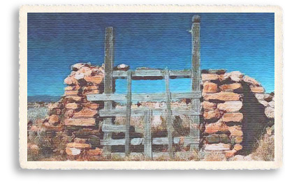 An old wooden gate set between stone pillars still guards the old cemetary at Gallisteo, New Mexico, just a few miles off the Turquoise Trail near the Garden of the Gods red rocks formation.